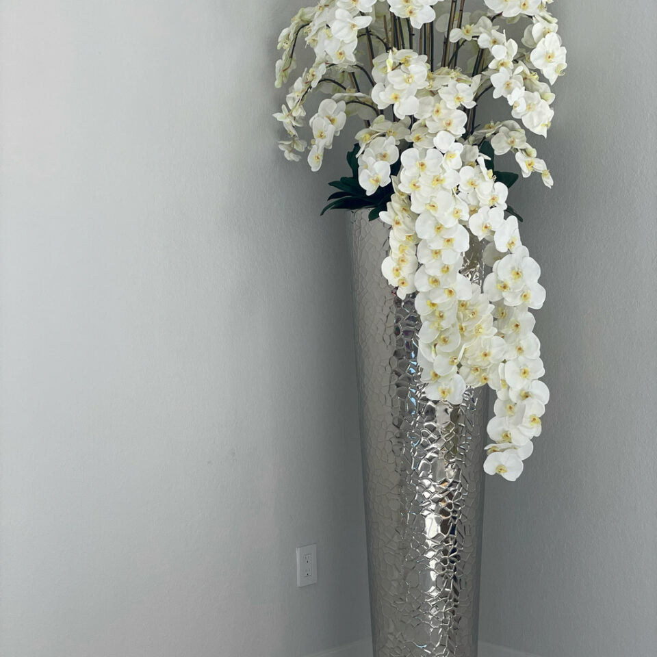 Kaskadierende Phalaenopsis-Orchideen in extra hoher, gehämmertem Vase