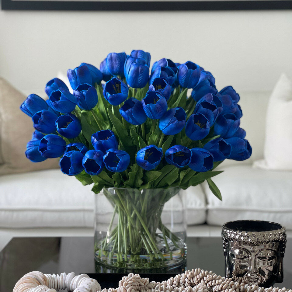 Blaues Tulpenarrangement in großer Zylindervase